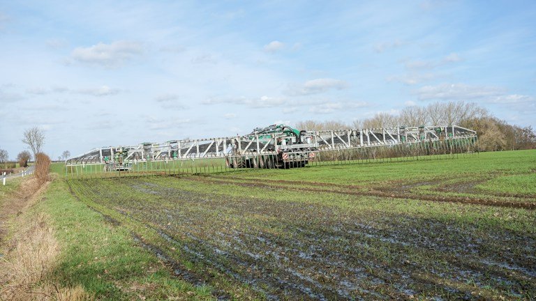 Máquina agrícola em lavoura comercial representando operação de aplicação foliar