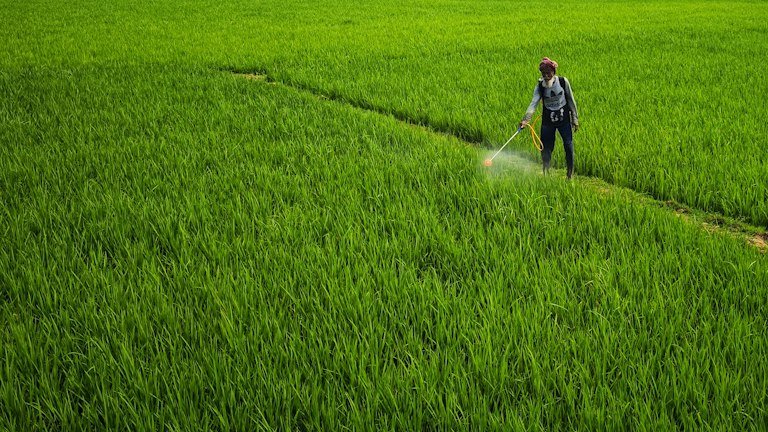 Aplicação agrícola com pulverizador costal representando cálculo de AZON conforme o volume de calda