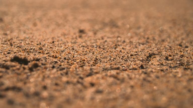 Solo agrícola em detalhe representando troca catiônica, complexação e interações químicas