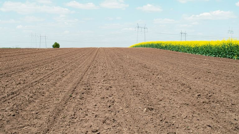 Solo agrícola preparado representando ciclos de molhamento, secagem e envelhecimento de materiais no perfil