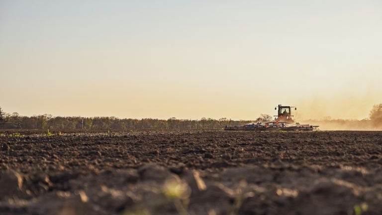 Operação agrícola em solo compactado representando resistência mecânica, porosidade e manejo do perfil