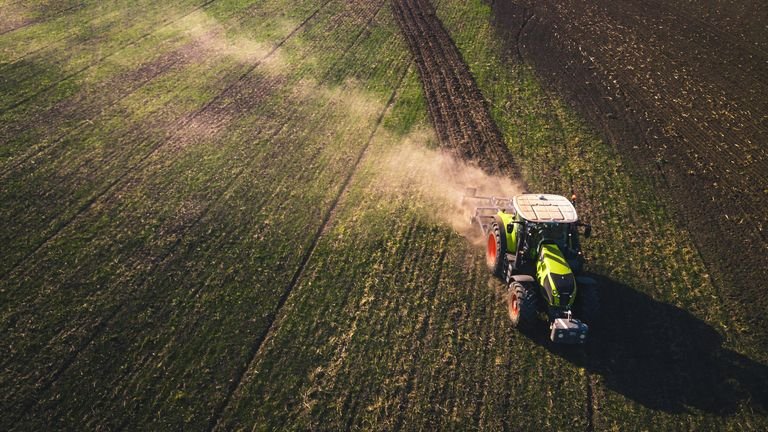 Máquina agrícola em lavoura representando aplicação de nutrientes e balanço de adubação no campo